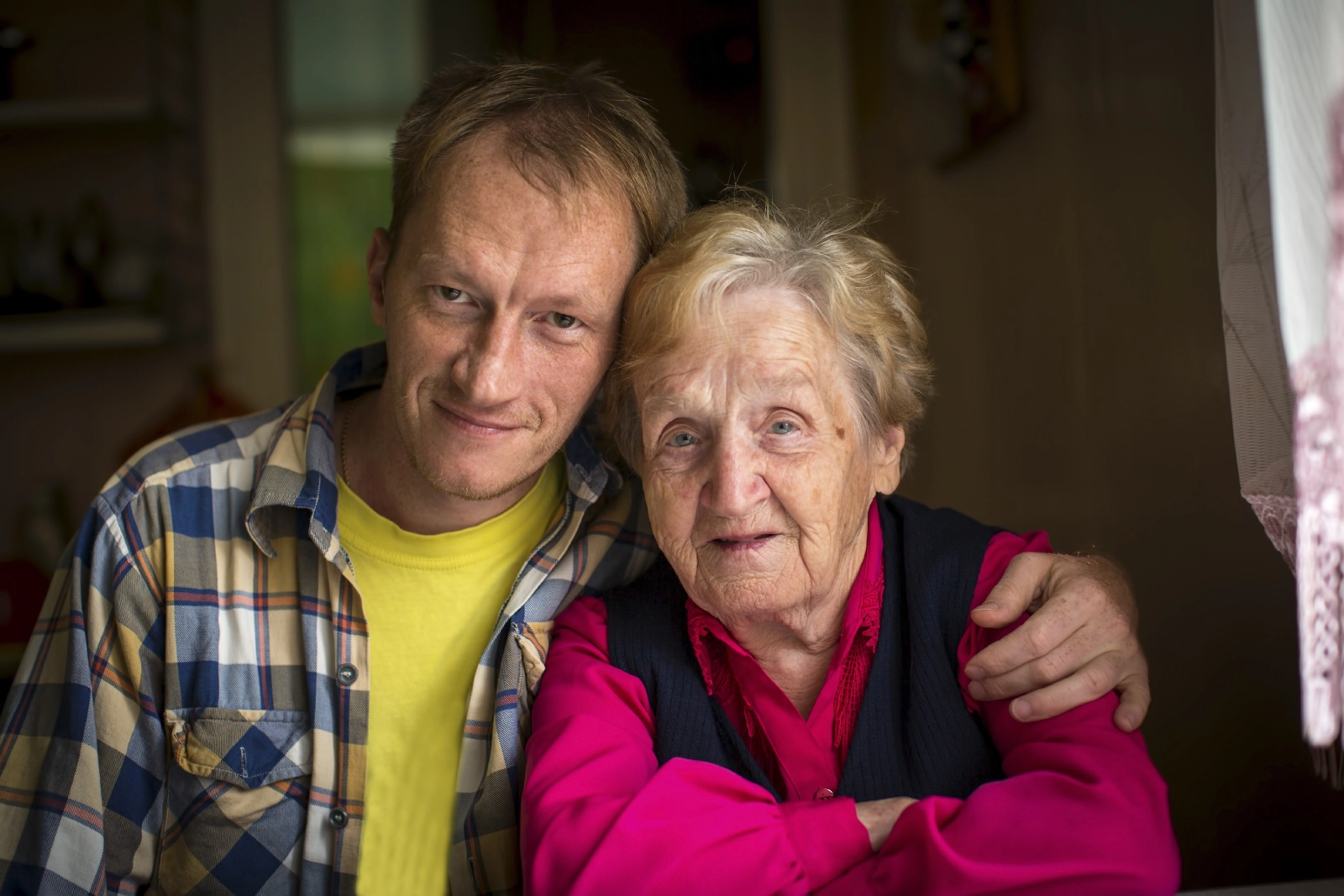 Senior couple sitting on a bench outdoors, talking and drinking tea.